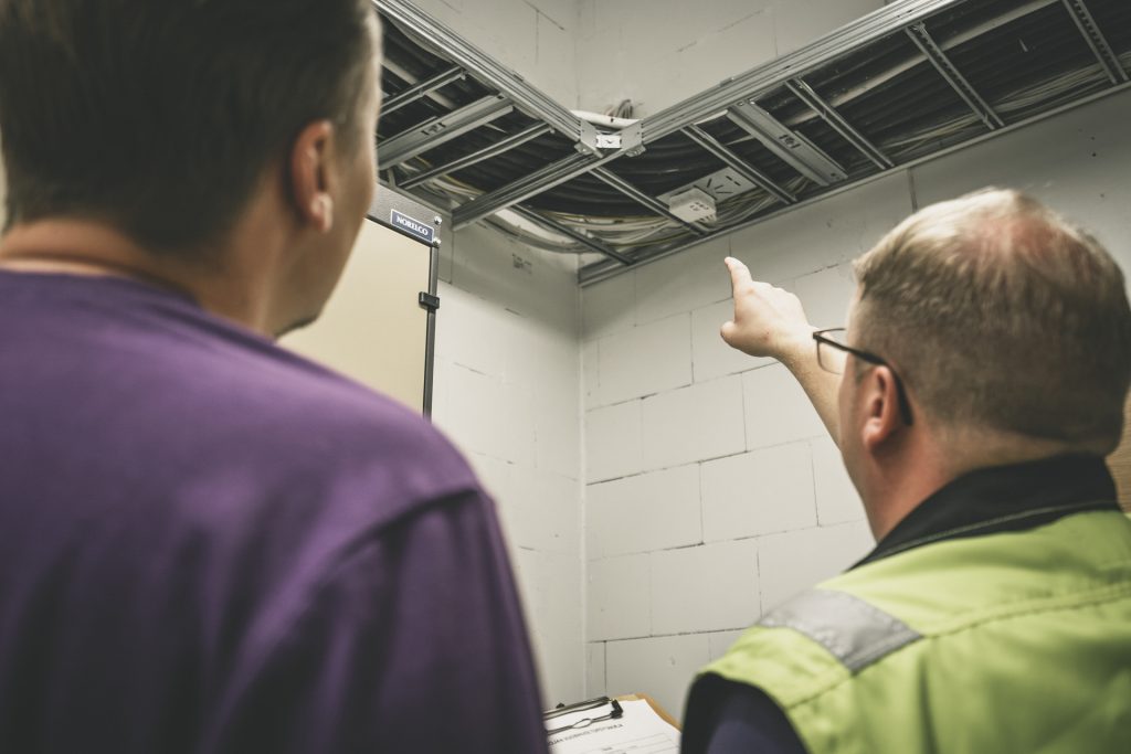 Kata Safetyn Joni ja Janne Rahunen katsomassa sähkötilan avointa läpivientiä